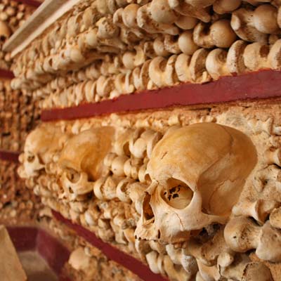 Bone chapel with a wall lined with human skulls.